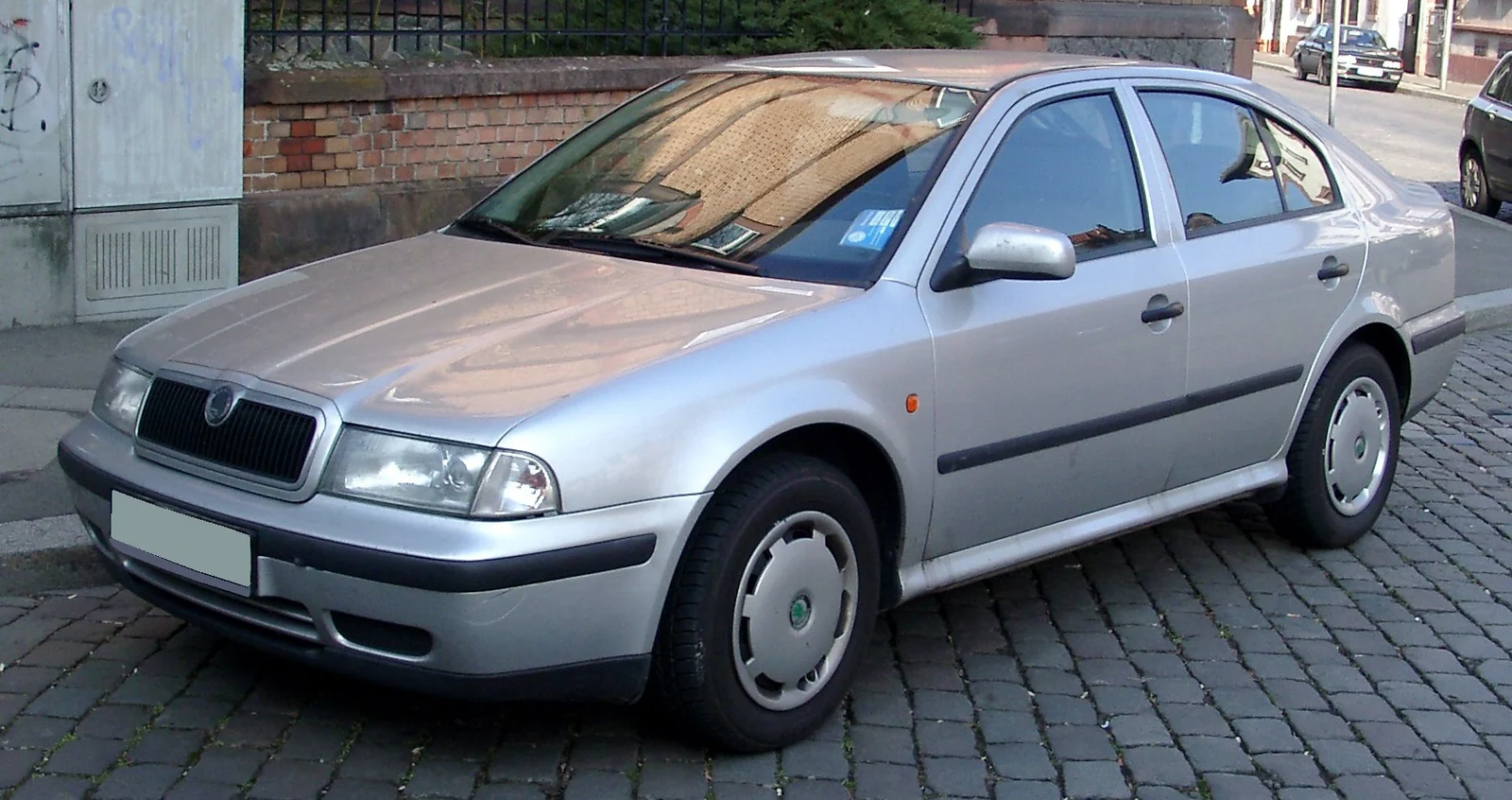 Silver first-generation Skoda Octavia liftback parked on a brick surface, photographed from the front three-quarter angle