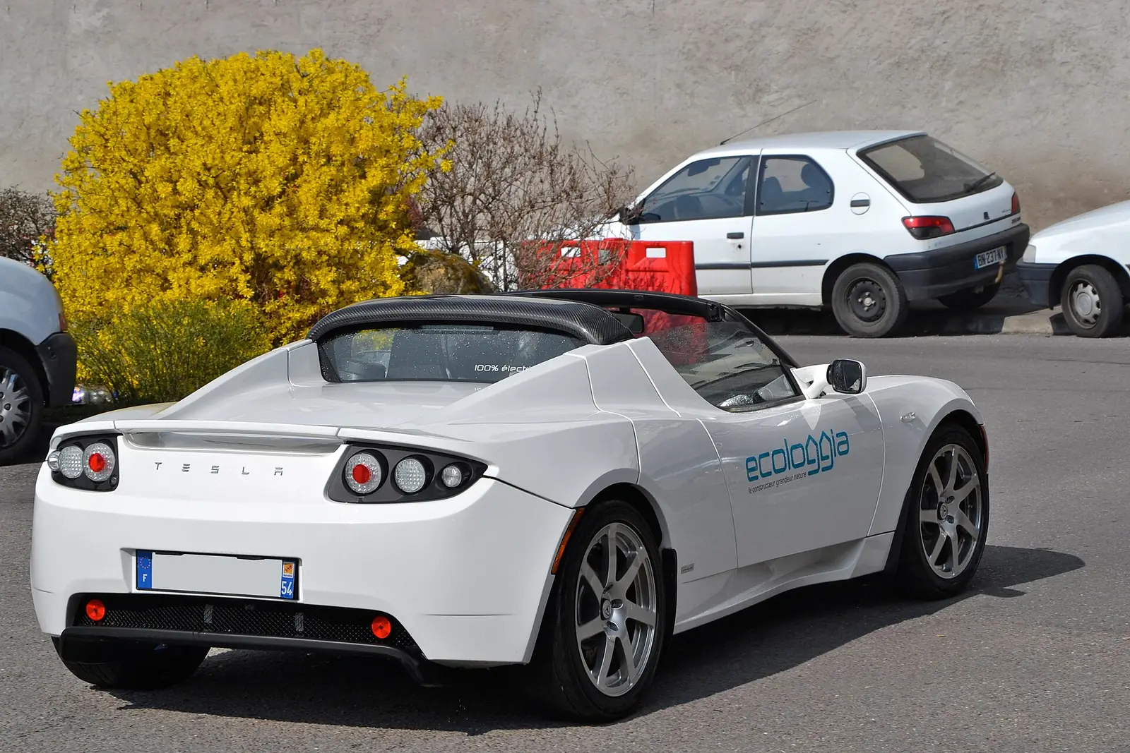 White Tesla Roadster photographed from the rear three-quarter angle with its soft top removed