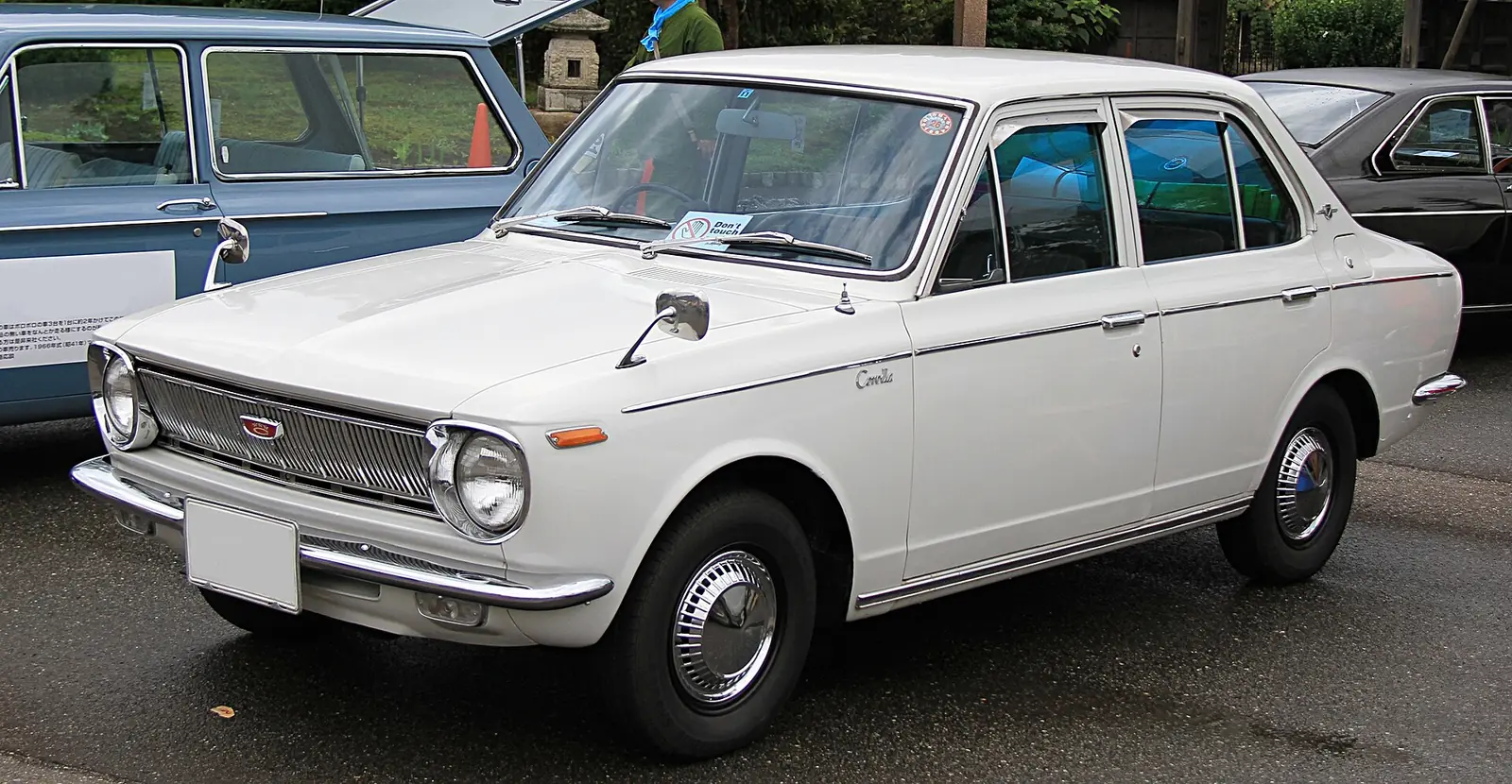 White 1968 Toyota Corolla 1100 Deluxe two-door saloon photographed from the front three-quarter angle in a museum setting