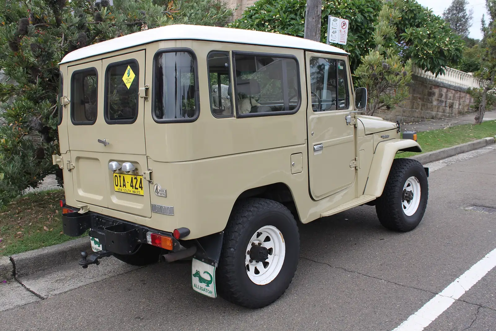 Beige Toyota Land Cruiser FJ40 hardtop photographed from the rear three-quarter angle