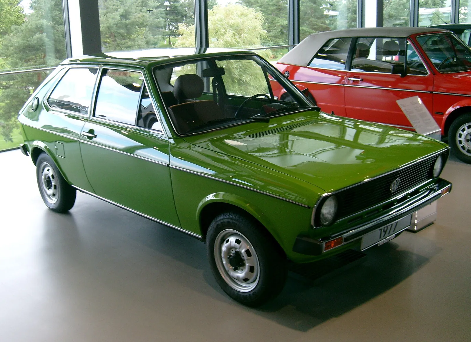 Green Volkswagen Polo Mk1 hatchback photographed from the front three-quarter angle indoors