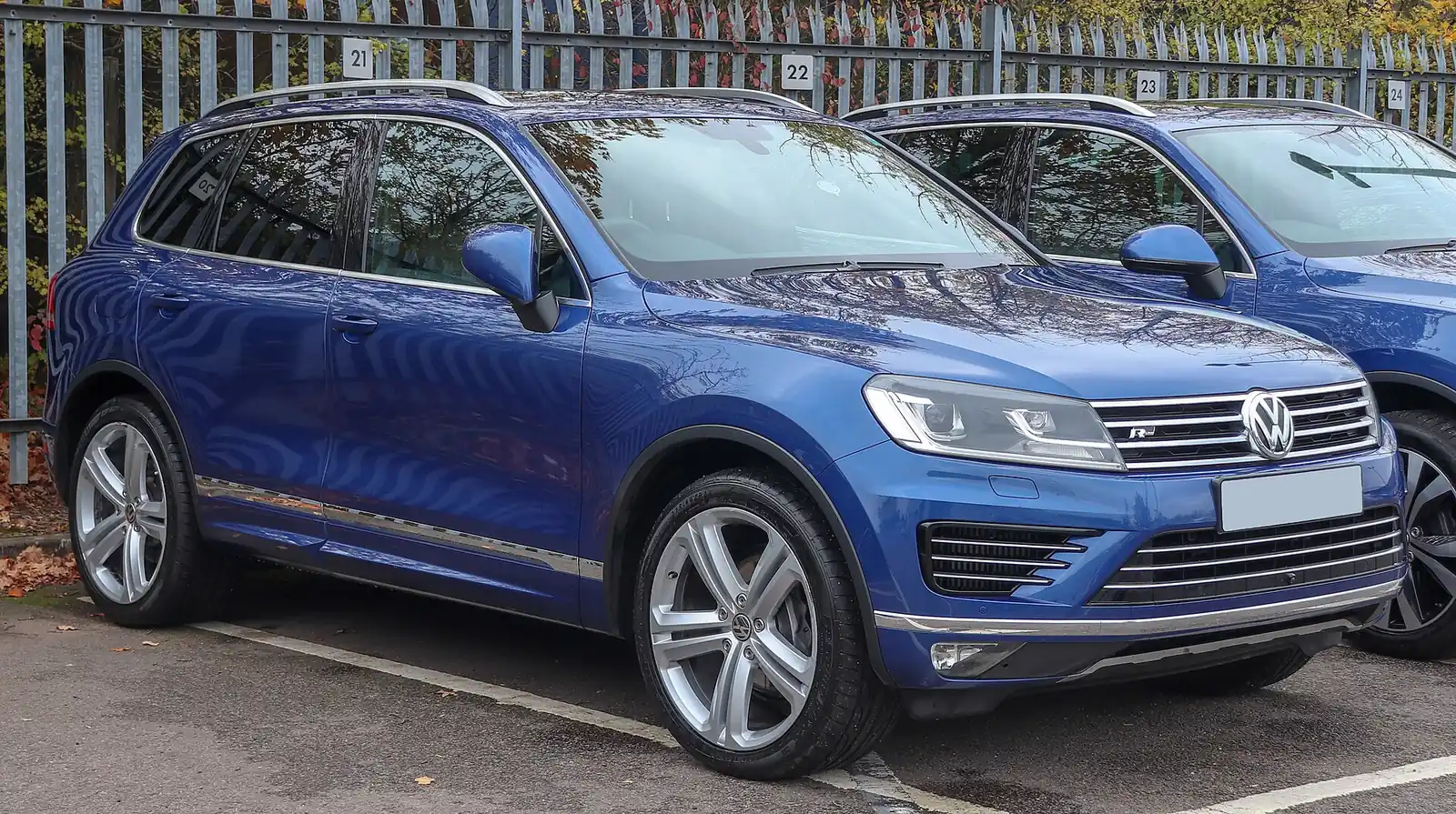 Blue second-generation Volkswagen Touareg R-Line SUV photographed from the front three-quarter angle in a car park