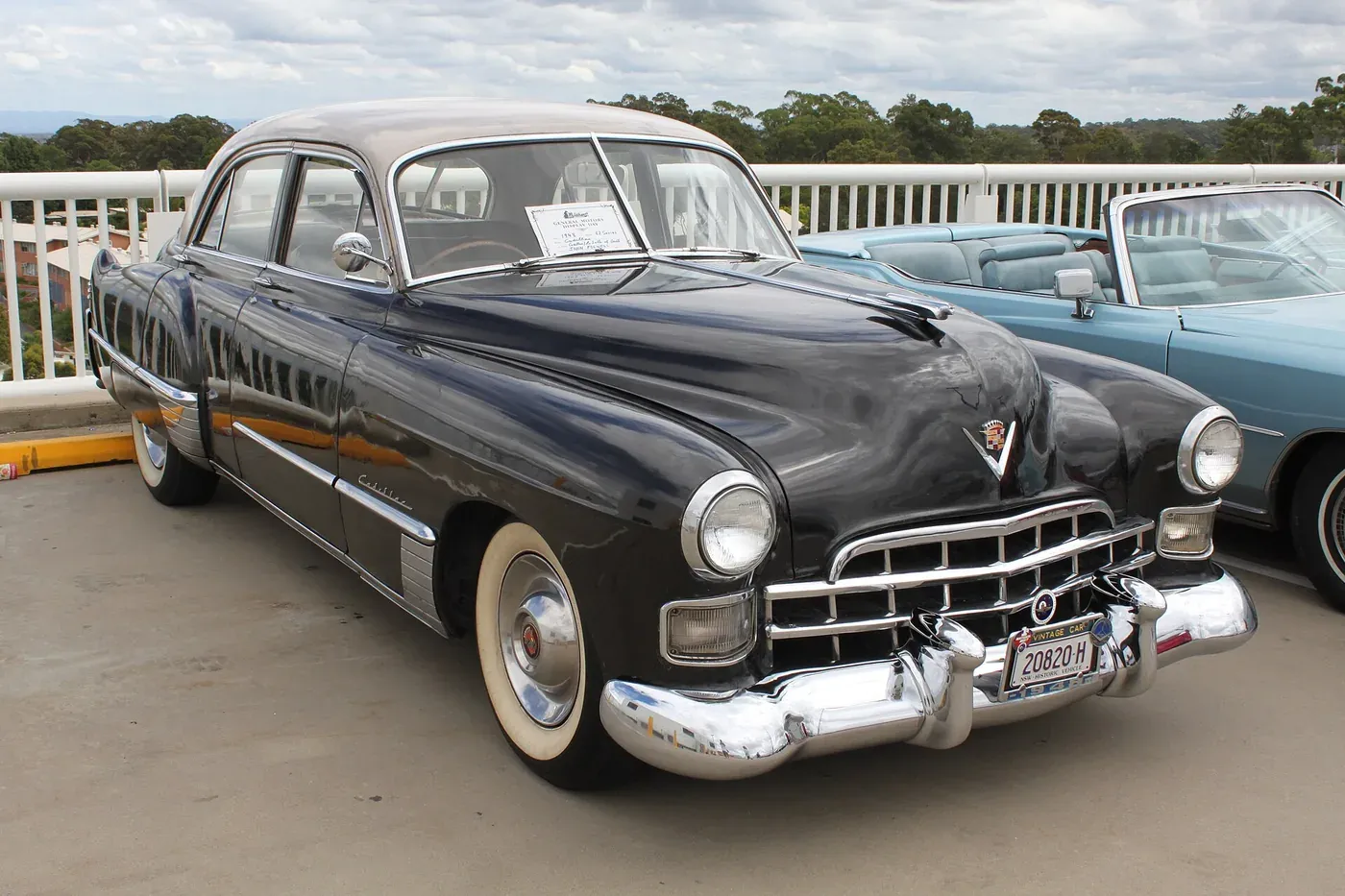 A black 1948 Cadillac sedan with chrome bumpers and grille, parked among other vintage cars at an outdoor car show.