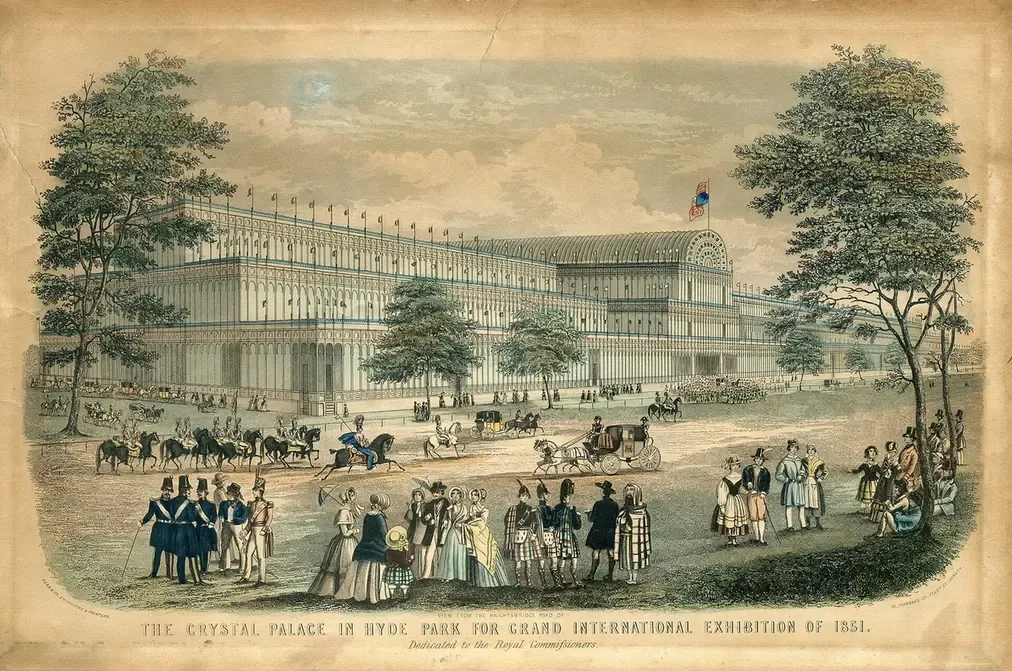 An engraving of a vast glass-and-iron exhibition building with rounded transepts, seen from a park road with carriages passing in front.