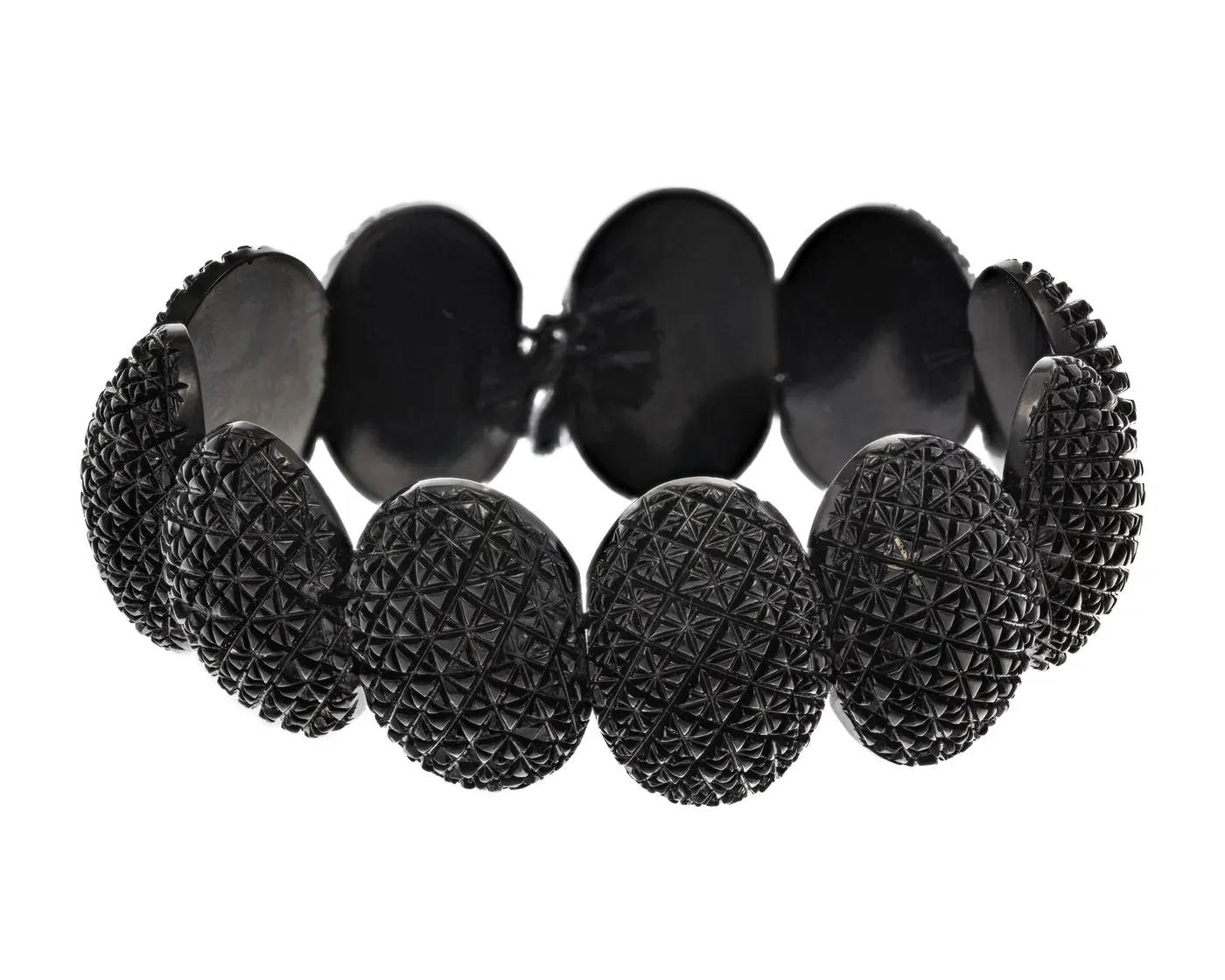 A dark, glossy hinged bracelet with a hand-carved openwork design, photographed against a plain background.