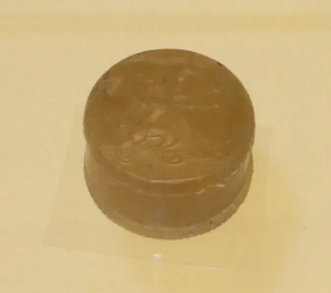 A small, plain, dark cylindrical pillbox with a fitted lid, resting on a pale surface.