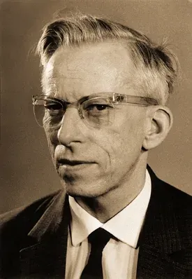 A formal black-and-white portrait of a balding man in glasses, wearing a dark suit and tie.