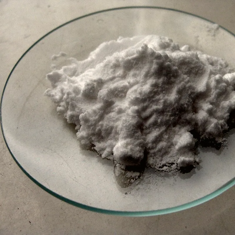 A small heap of fine white bicarbonate of soda on a glass dish