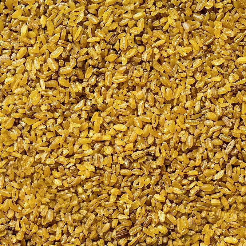 A close, even field of fine dry bulgur, pale gold and angular