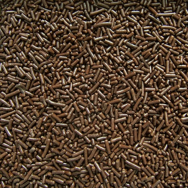 A close view of chocolate sprinkles, small rod-shaped pieces piled together