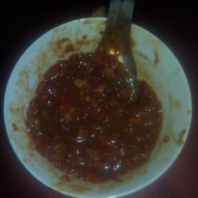 A bowl of dark red, chunky fermented broad bean and chilli paste (doubanjiang)