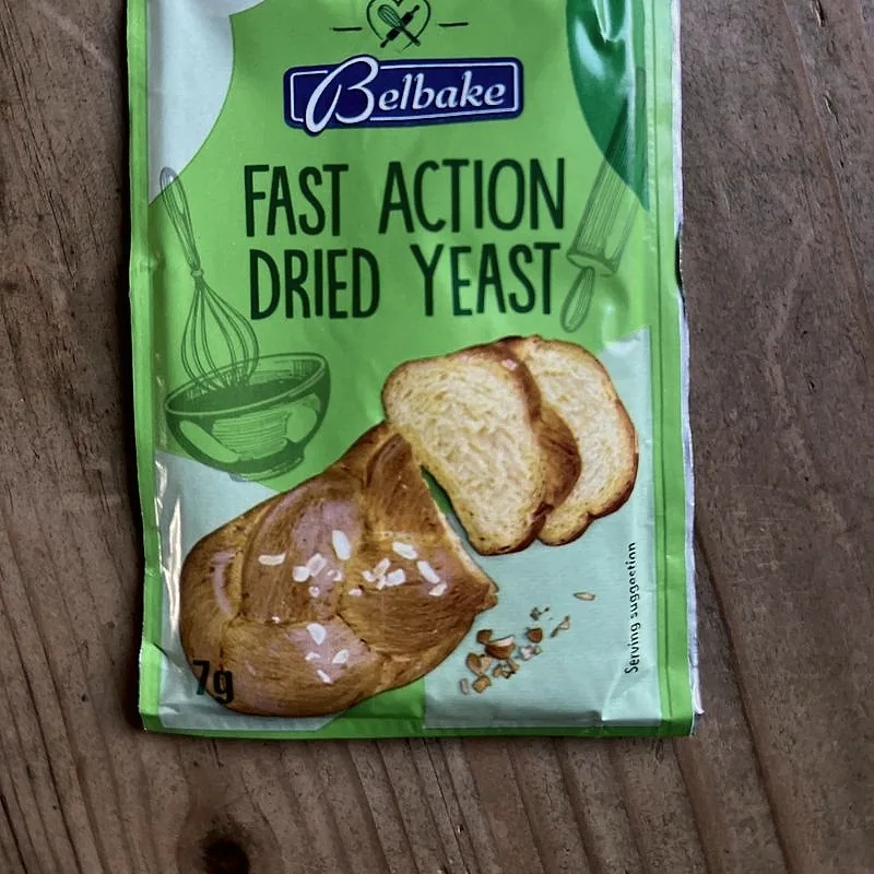 A sealed sachet of fast-action dried yeast on a wooden board
