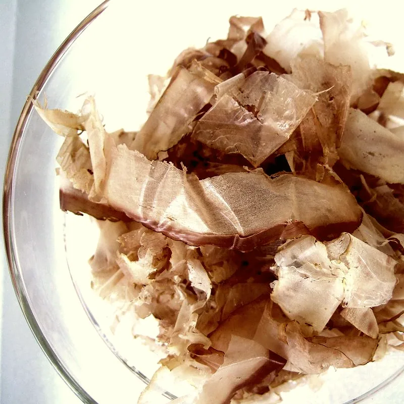 A bowl of pale brown katsuobushi, shaved into thin curling flakes