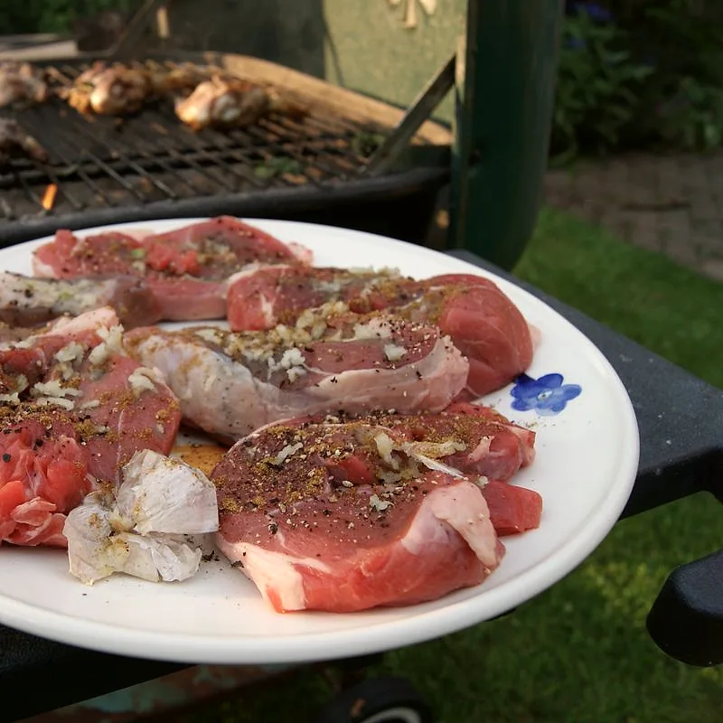 Raw lamb steaks seasoned with garlic and pepper, ready for the grill