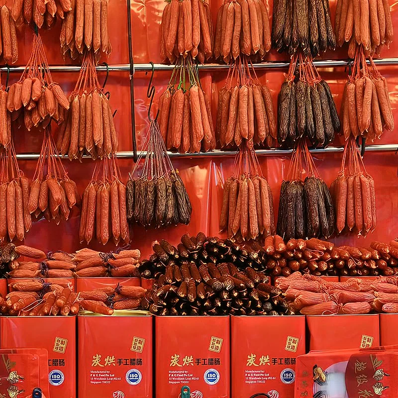 Rows of glossy, dark red Chinese cured sausages (lap cheong) hanging in a shop
