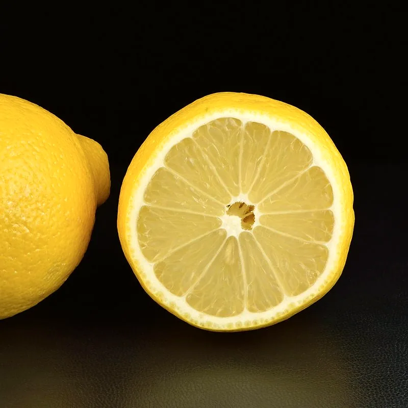 A whole lemon beside a lemon half showing its juicy segmented flesh