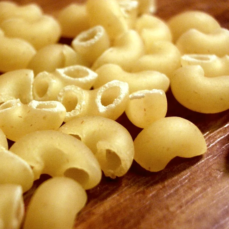 A close-up pile of dried elbow macaroni pasta