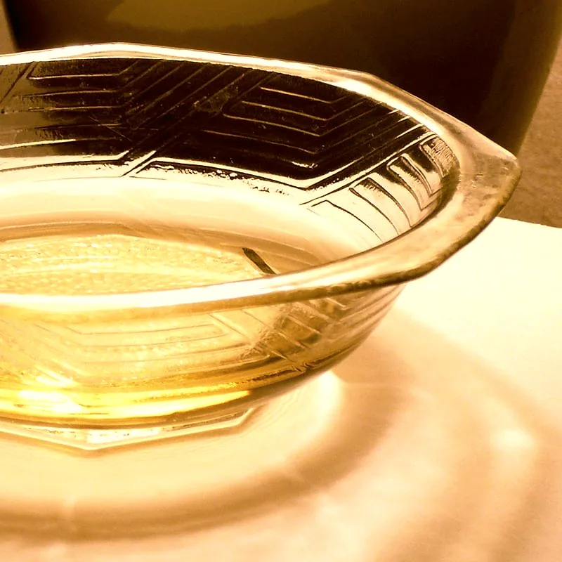 A small glass bowl containing pale gold mirin