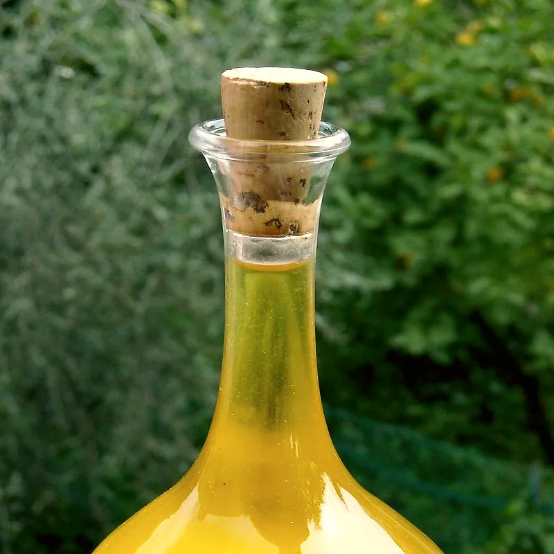 A glass carafe of green-gold olive oil