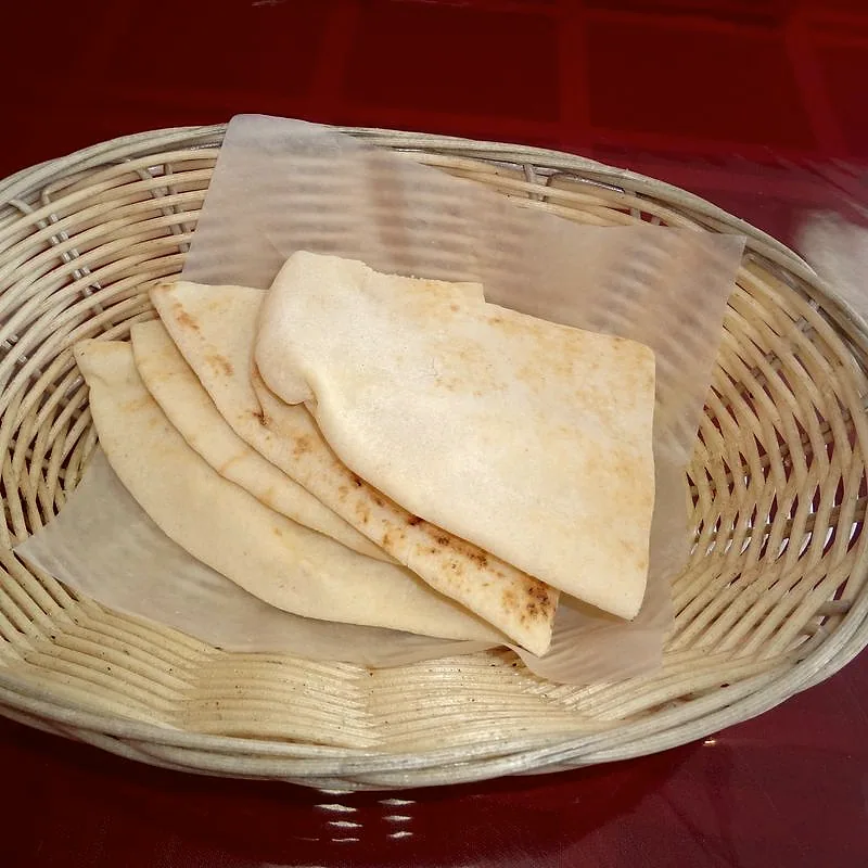 Folded wedges of pita bread in a woven basket