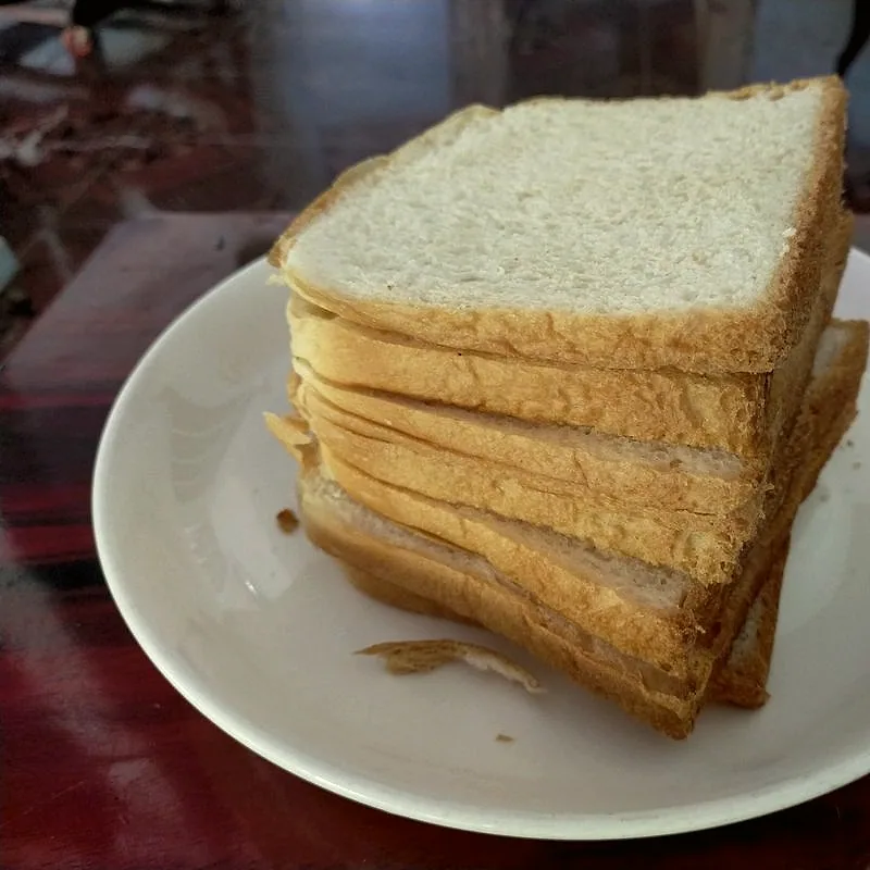 A stack of sliced white sandwich bread on a plate