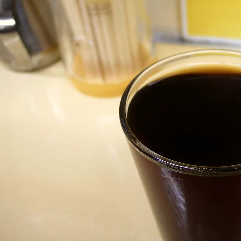 A glass filled with dark amber Shaoxing rice wine