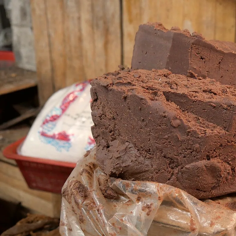 A dense block of dark purplish-brown fermented shrimp paste