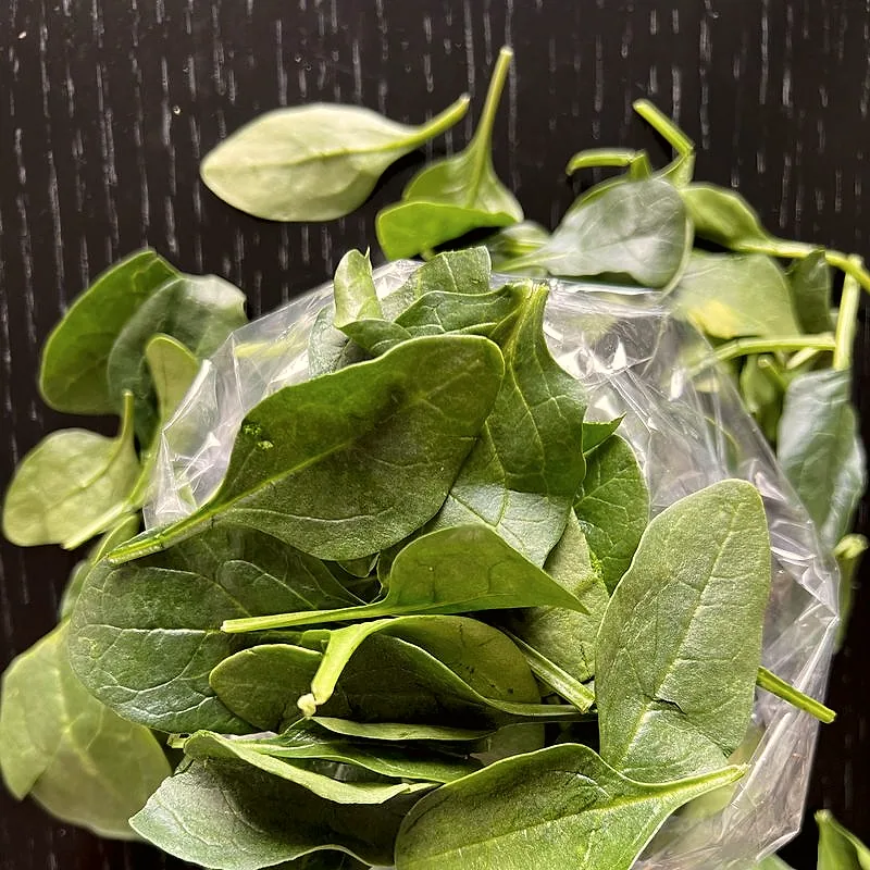 A pile of fresh green spinach leaves