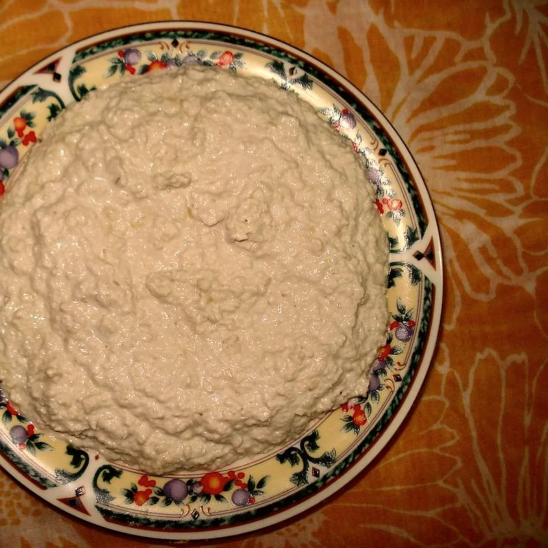 A shallow bowl of pale tahini, thick and slightly separated