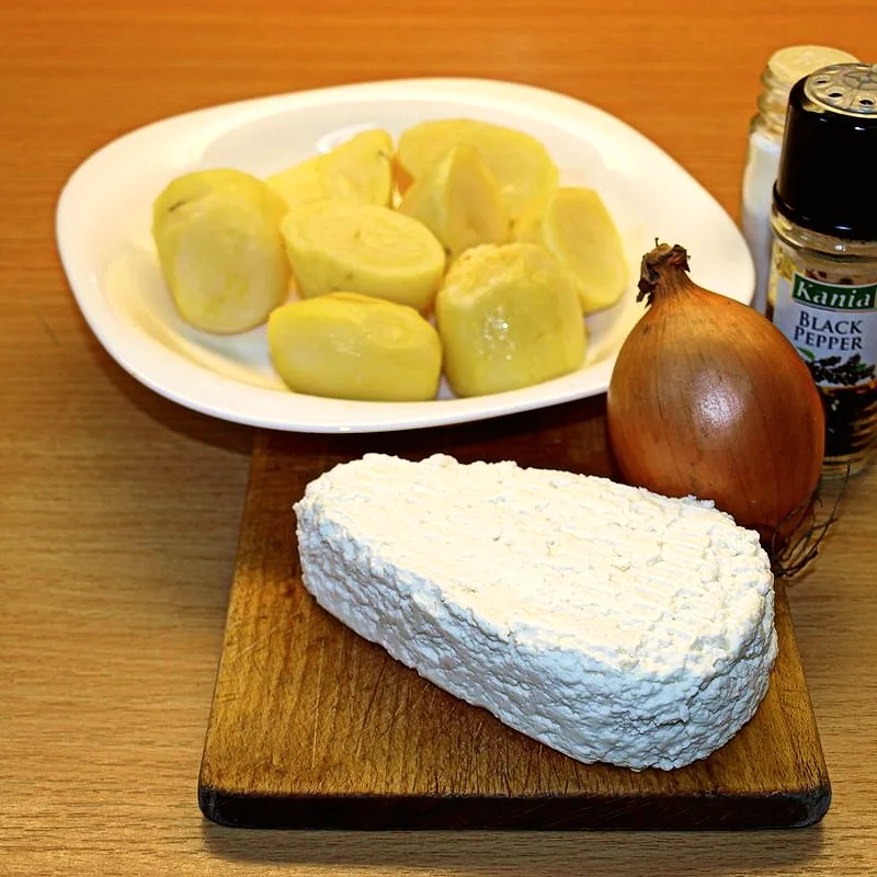 A block of twaróg, pressed dry-curd cheese, with potatoes and onion