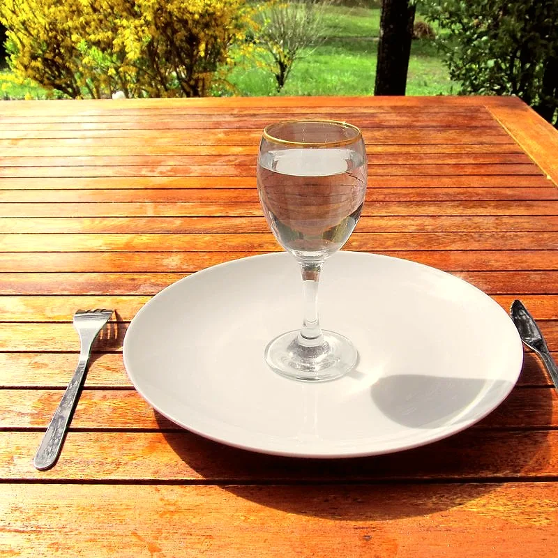 A glass of clear water standing on a plate