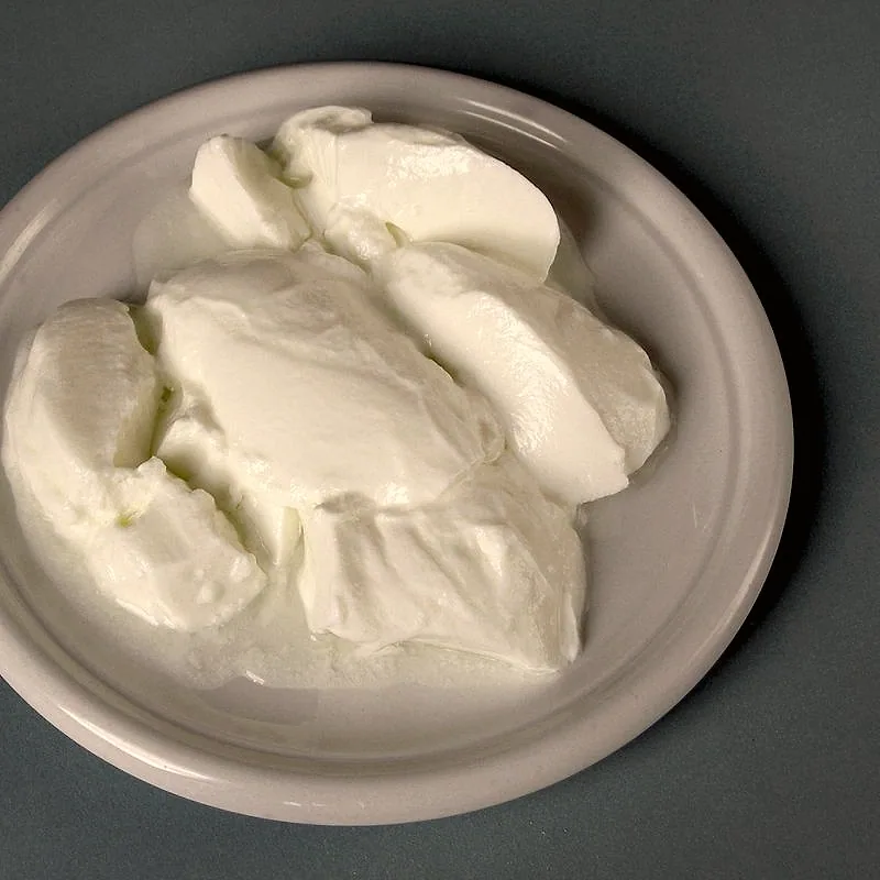 Plain whole-milk yoghurt spooned onto a pale plate