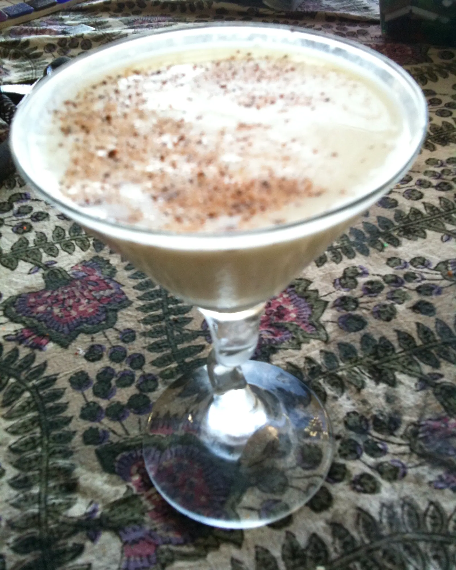 A pale cream cocktail dusted with grated nutmeg, served in a coupe glass
