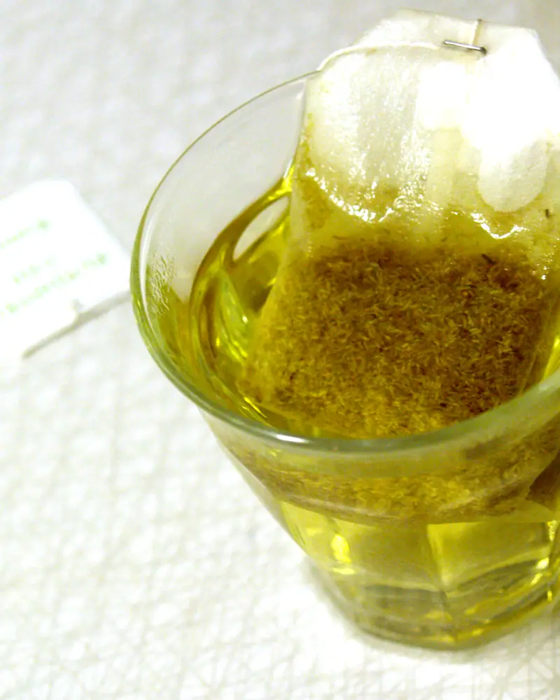 A glass cup of pale golden chamomile tea