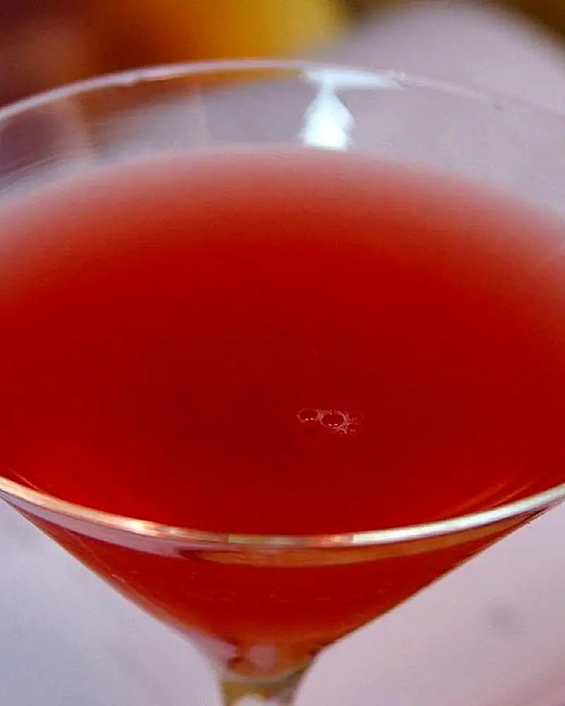 A close view of a Cosmopolitan's deep pink-red colour in a cocktail glass