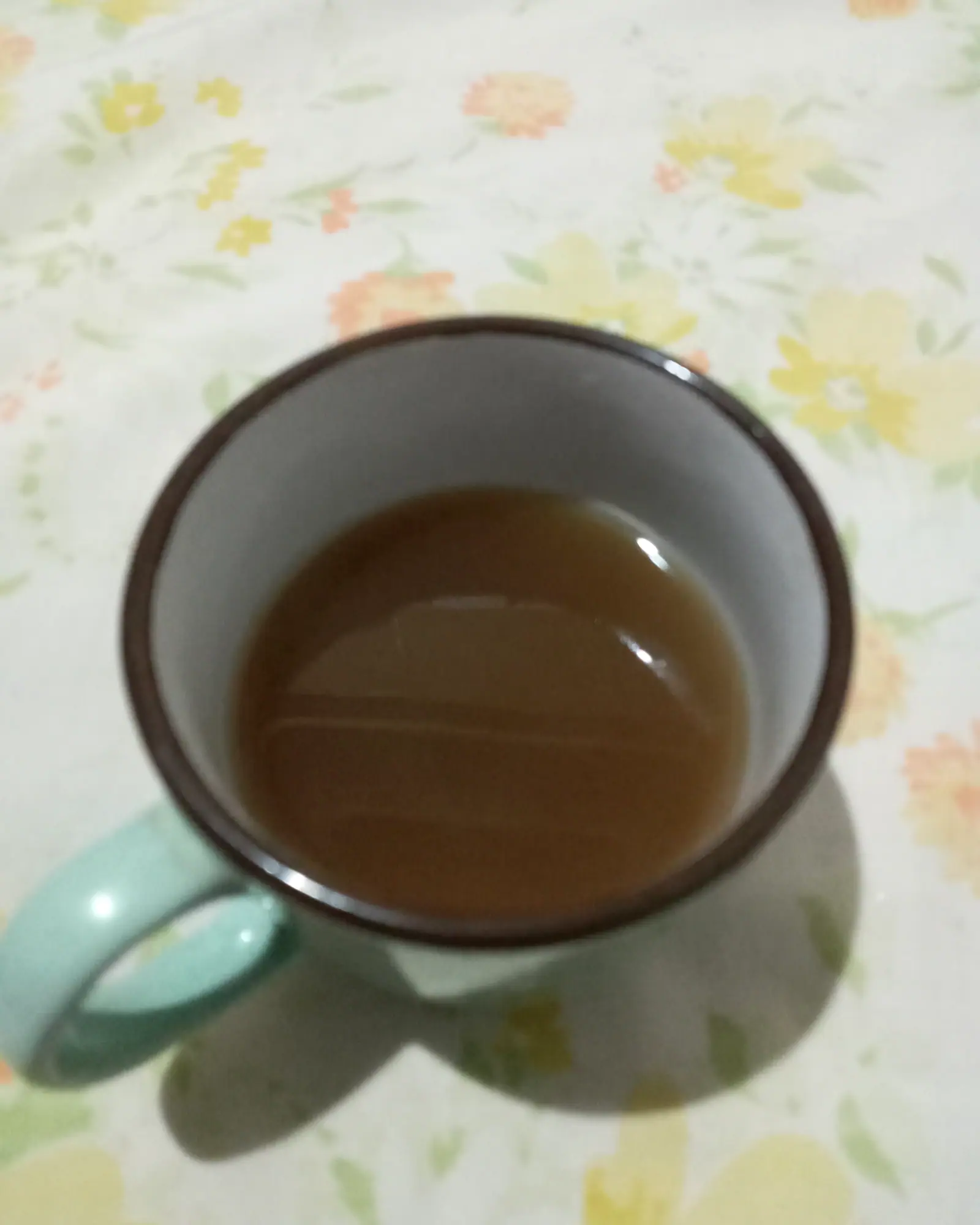 A mug of amber ginger tea, viewed from above