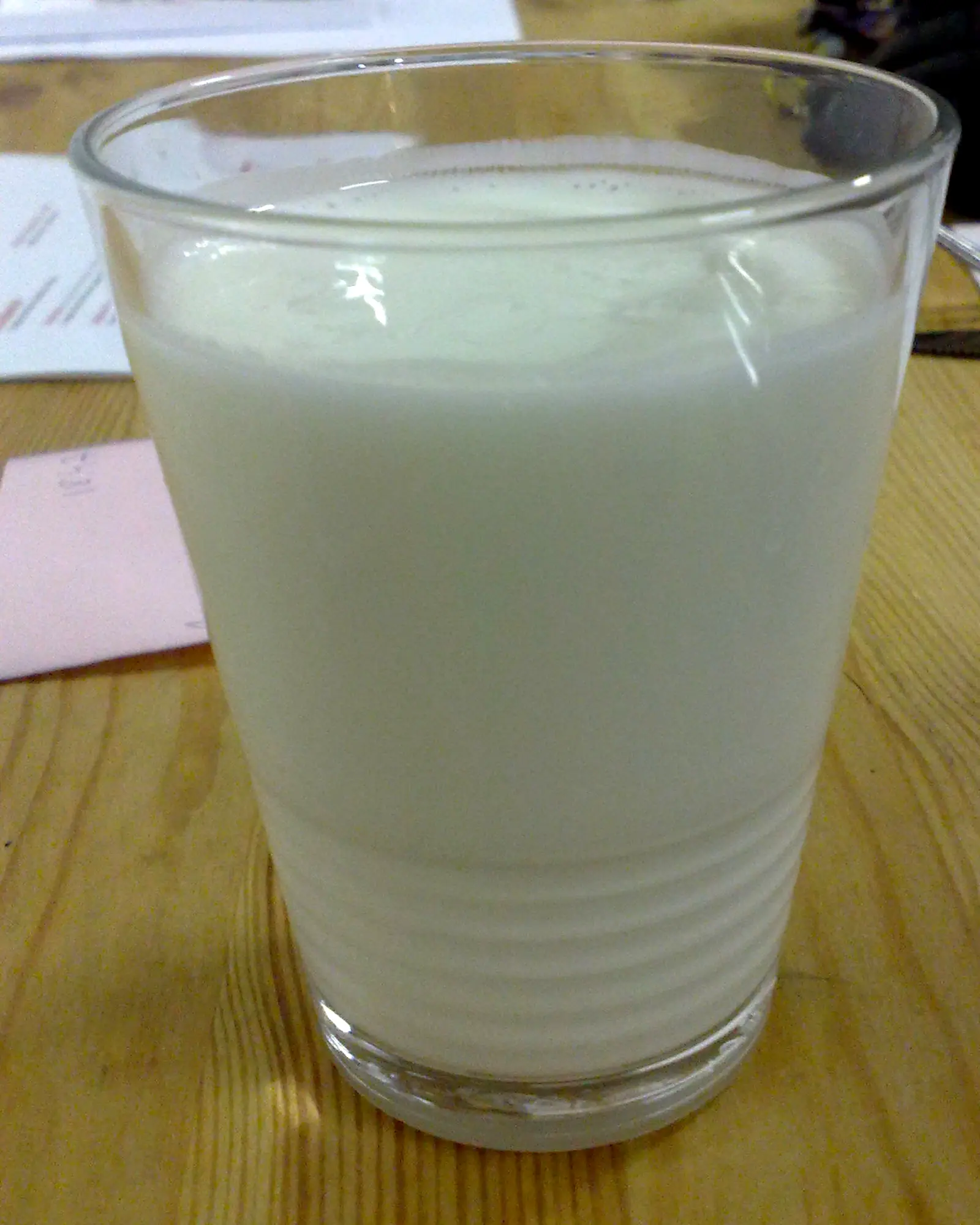 A glass of pale, thick white milk kefir