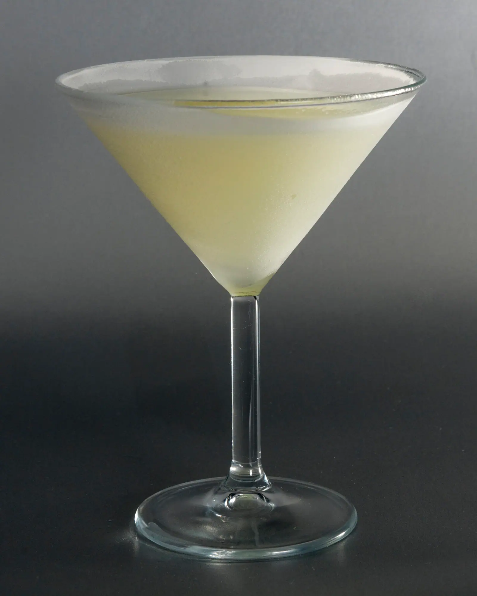 A pale yellow-green Last Word cocktail served up in a martini glass