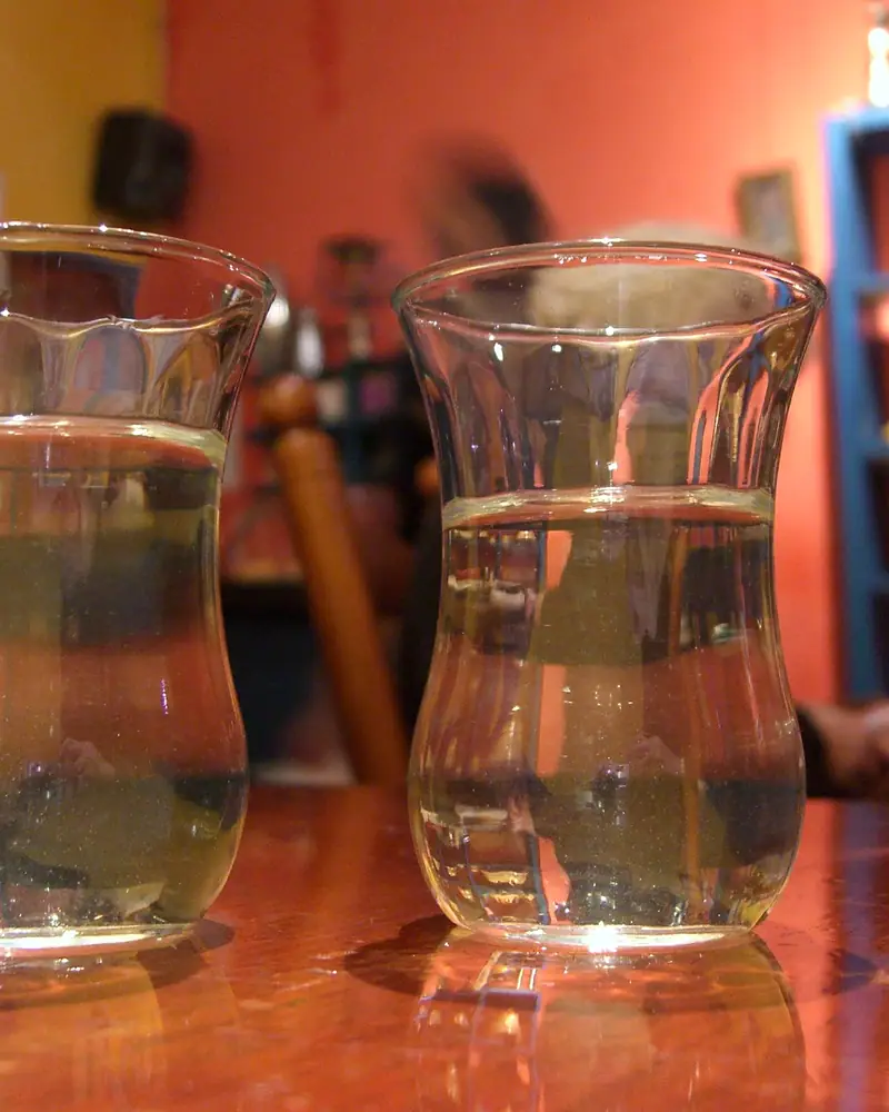 Two small glasses of Moroccan mint tea on a wooden counter