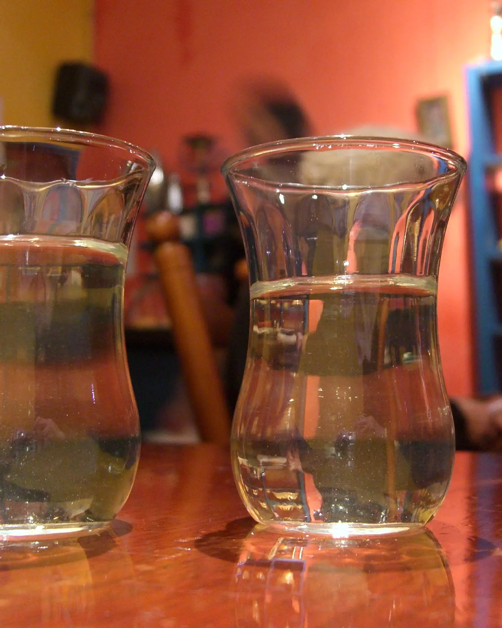 Two small glasses of Moroccan mint tea on a wooden counter