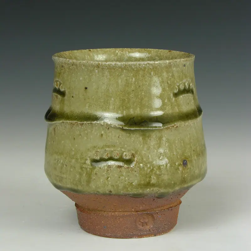 An empty handleless ceramic yunomi teacup with an ash glaze