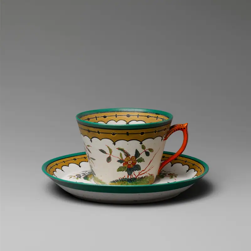 An empty, decorated porcelain teacup on its matching saucer