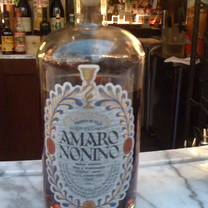 A bottle of Amaro Nonino Quintessentia on a bar counter, its label clearly visible