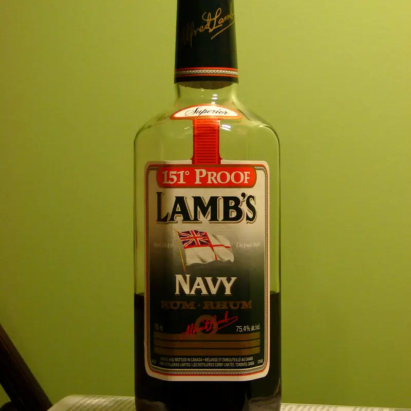 A bottle of dark navy rum with a red and gold label