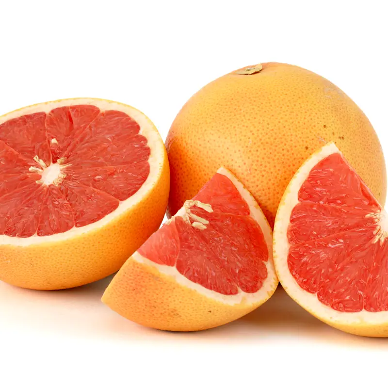 A whole pink grapefruit beside a halved and a quartered one, showing the pink flesh