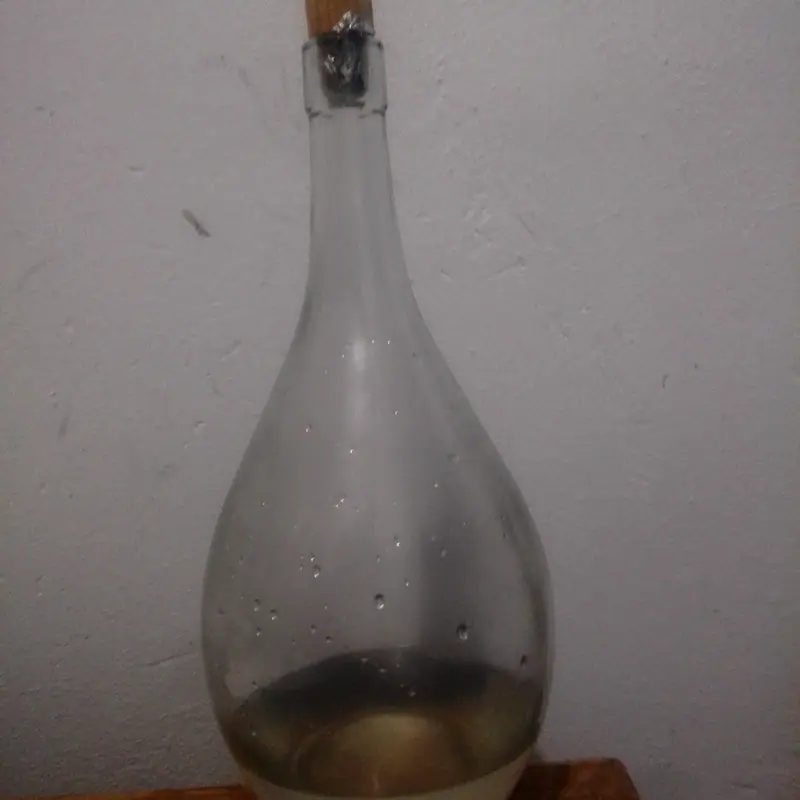 A traditional glass bottle of pale orange flower water