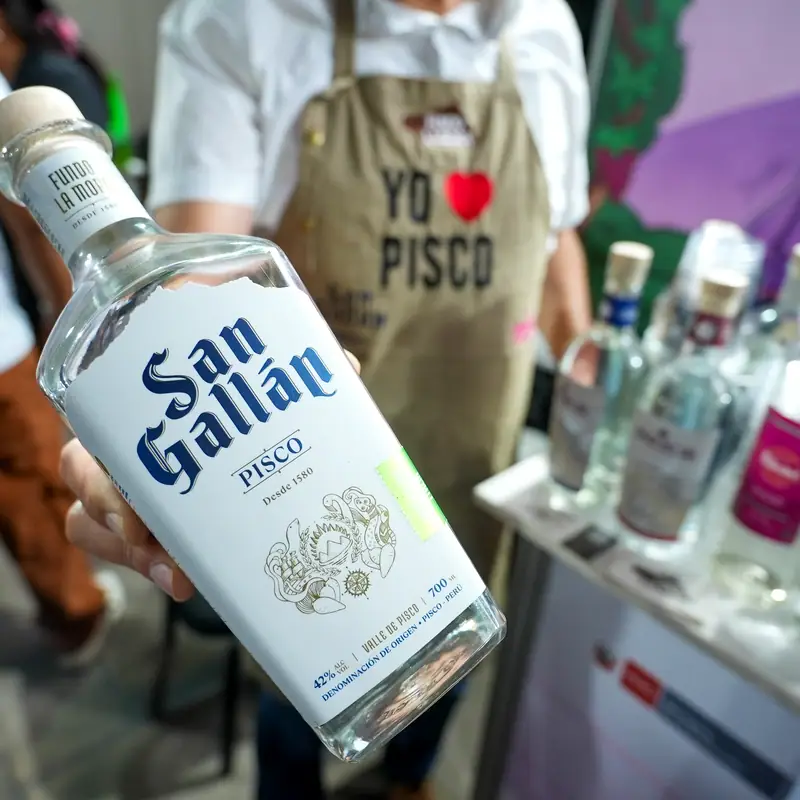 A bottle of San Gallán pisco held up at a pisco festival