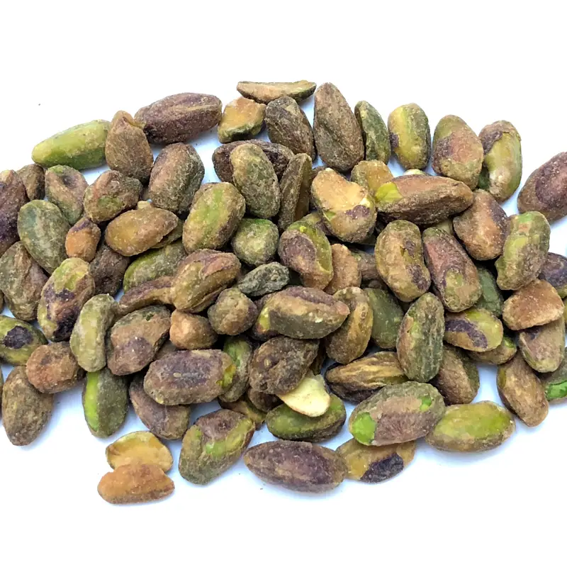 A pile of shelled roasted pistachio kernels, green with brown skin