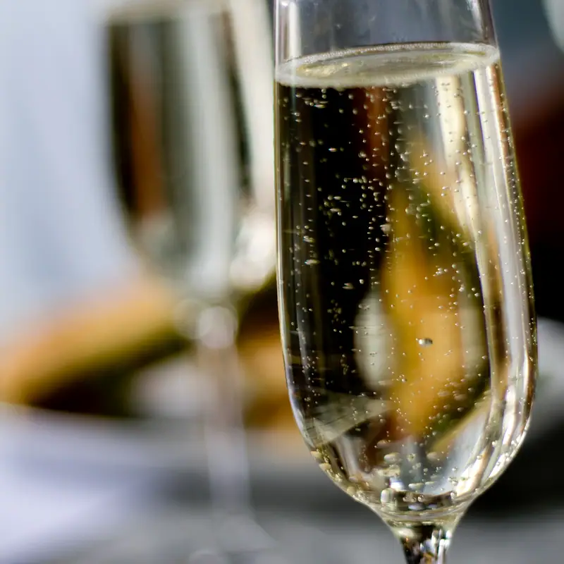 A flute of sparkling wine, bubbles rising through the pale gold liquid