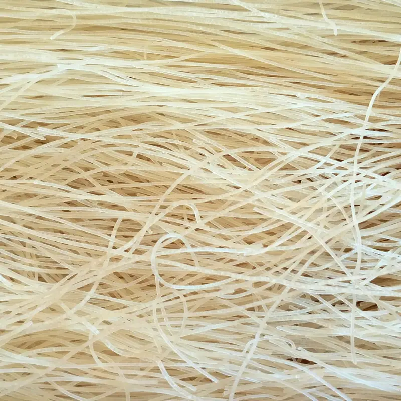 A close tangle of thin dry white rice vermicelli noodles